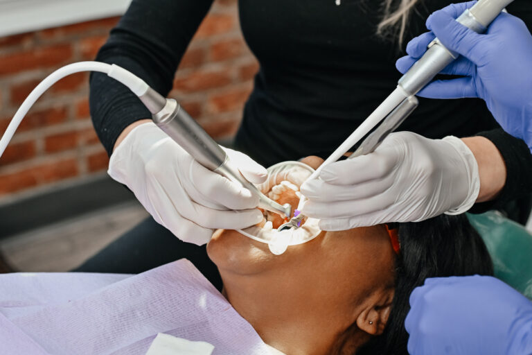 Dentist checking dental veneers during a follow-up visit to help prevent common veneer care mistakes.
