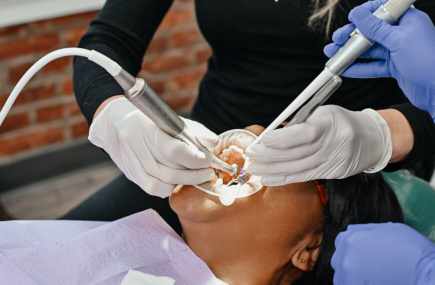 Dentist checking dental veneers during a follow-up visit to help prevent common veneer care mistakes.