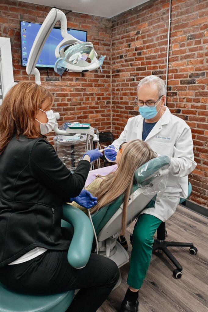 Dentist performing a comprehensive new patient dental exam with a dental assistant at A Plus Dentistry in Brookline, MA.