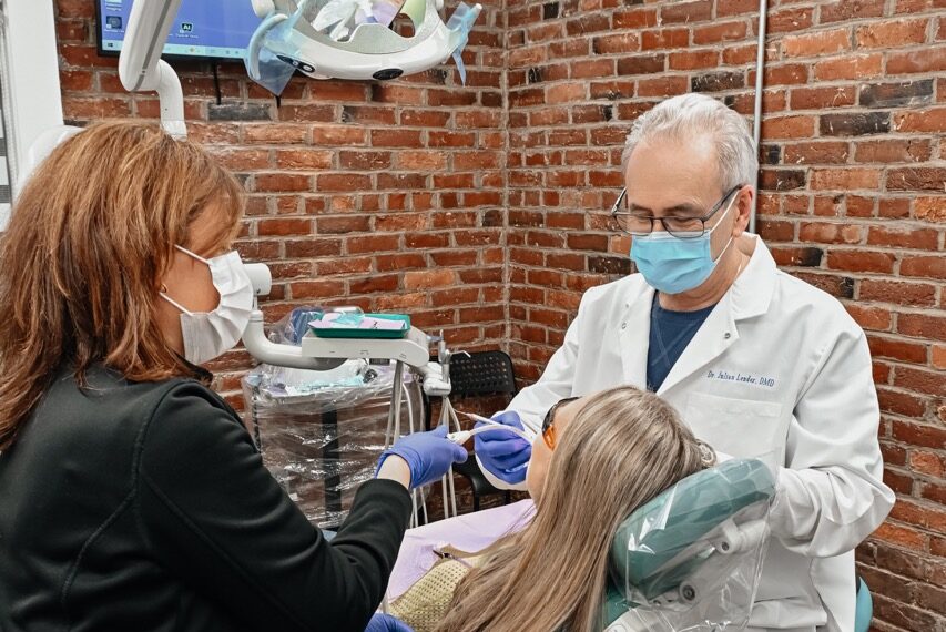 Dentist performing a comprehensive new patient dental exam with a dental assistant at A Plus Dentistry in Brookline, MA.