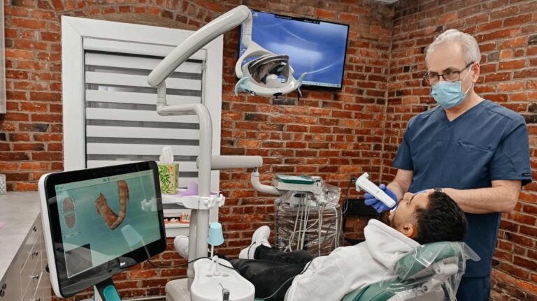 Dentist using a digital scanner to plan Invisalign treatment for a patient at A Plus Dentistry in Brookline, MA.