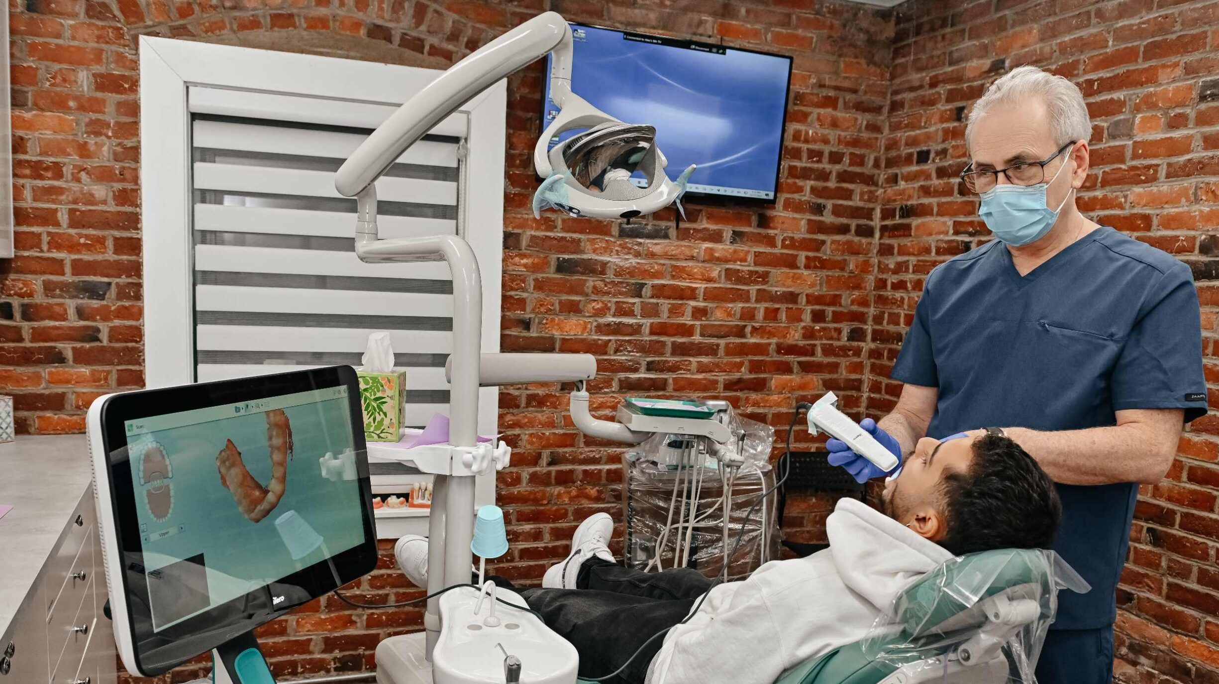 Dentist using a digital scanner to plan Invisalign treatment for a patient at A Plus Dentistry in Brookline, MA.